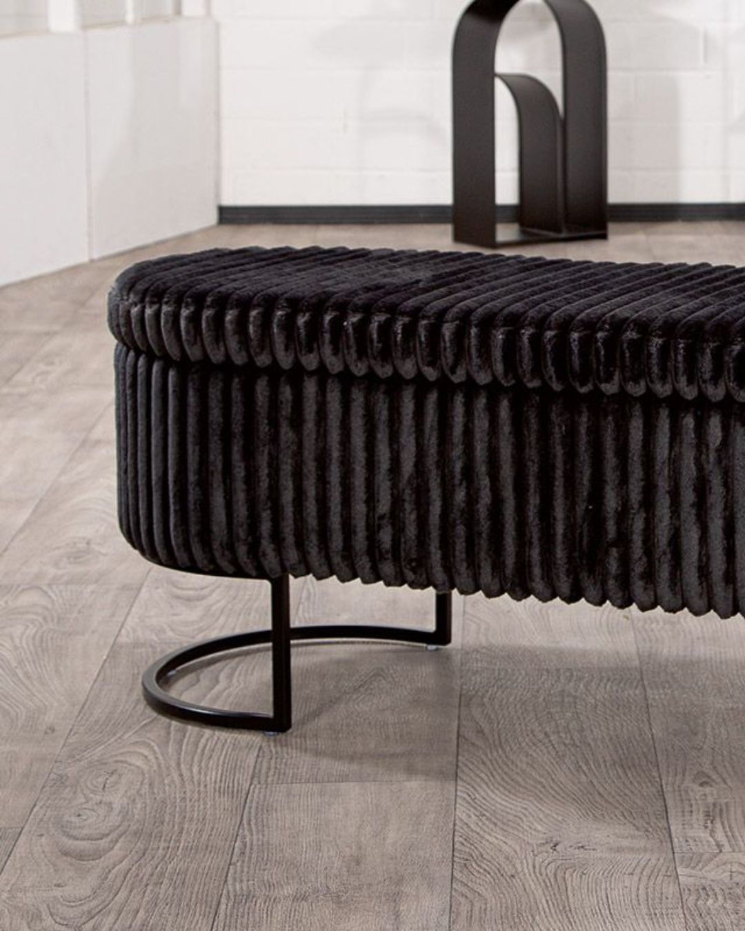  Kompakte schwarze Sitzbank in stilvollem Design, geeignet für verschiedene Raumgestaltungen.