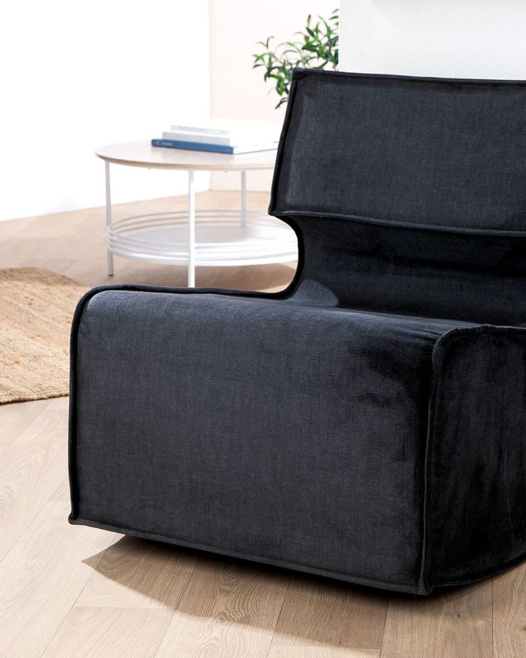 Seitenansicht des eleganten schwarzen Armchairs mit großzügiger Sitzfläche.