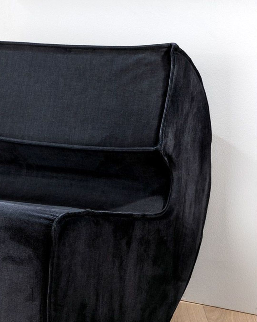 Detailansicht der schwarzen Stoffpolsterung des modernen Armchairs.