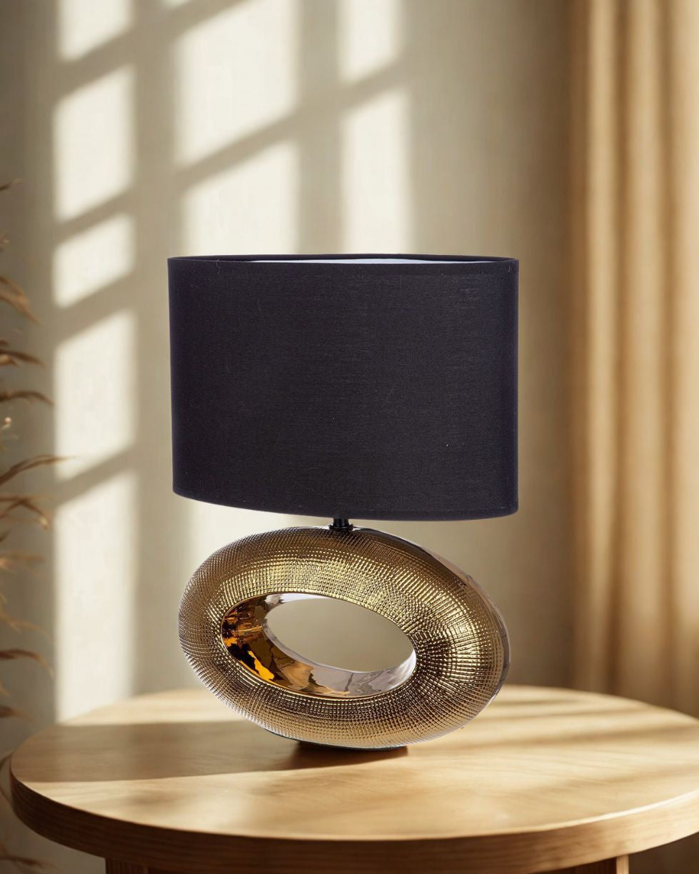 Ovale Tischlampe „Konya“ mit goldfarbener Keramikbasis und elegantem Design
