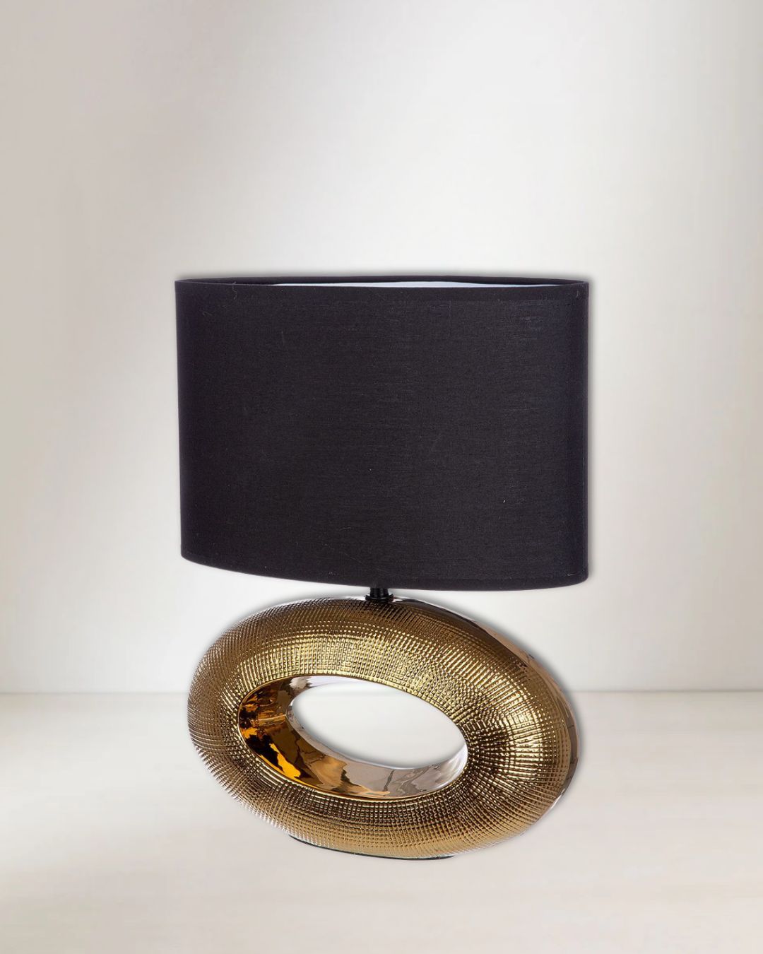 Ovale Tischlampe „Konya“ mit goldfarbener Keramikbasis und elegantem Design.