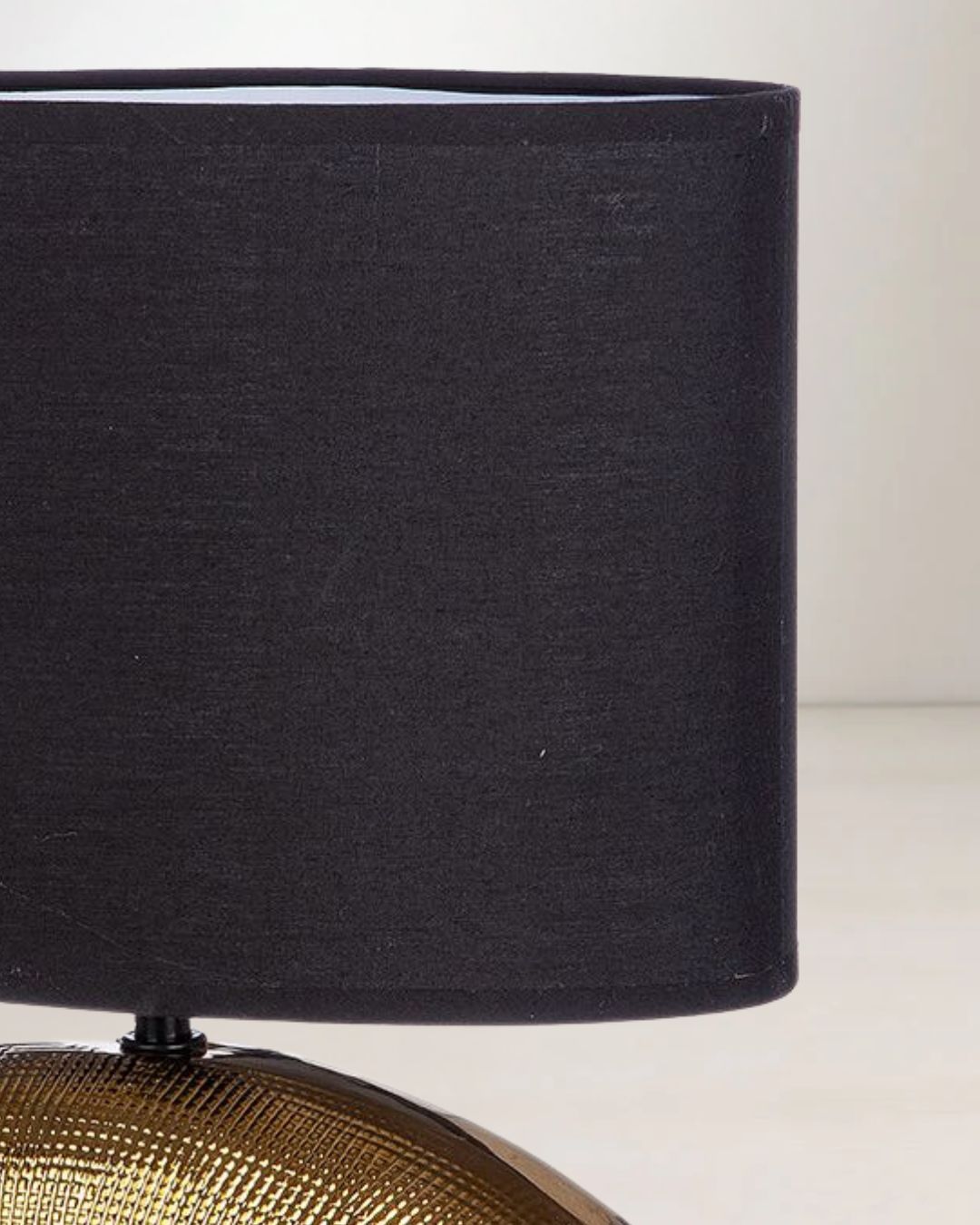 Detailaufnahme der glänzenden Goldkeramik des Lampensockels.