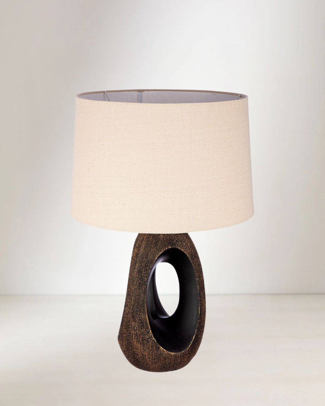 Ovale Tischlampe „Lusaka“ mit Keramiksockel in Beige und Schwarz.