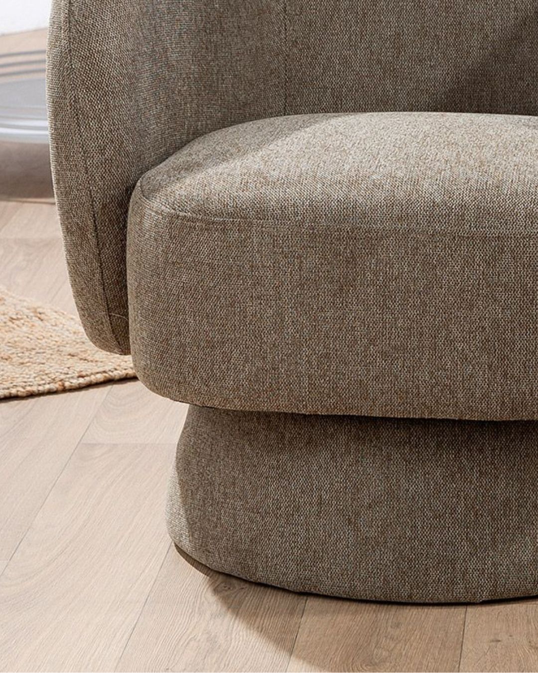 Seitenansicht des grauen "Rotunda" Sessels mit stilvollem, schlanken Design und weicher Polsterung.