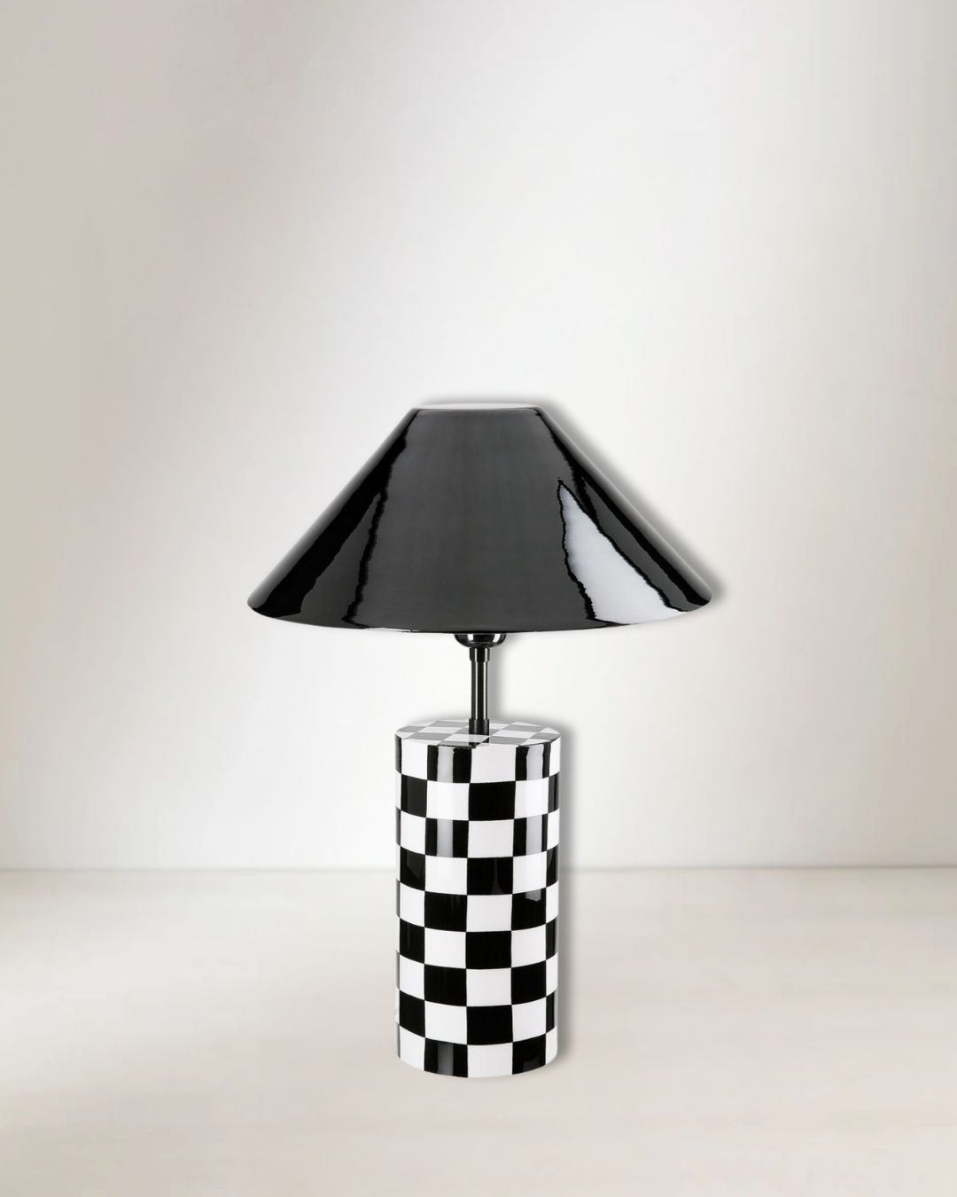 Zylindrische Tischlampe „Checkers“ aus schwarzem Eisen mit kariertem Muster.